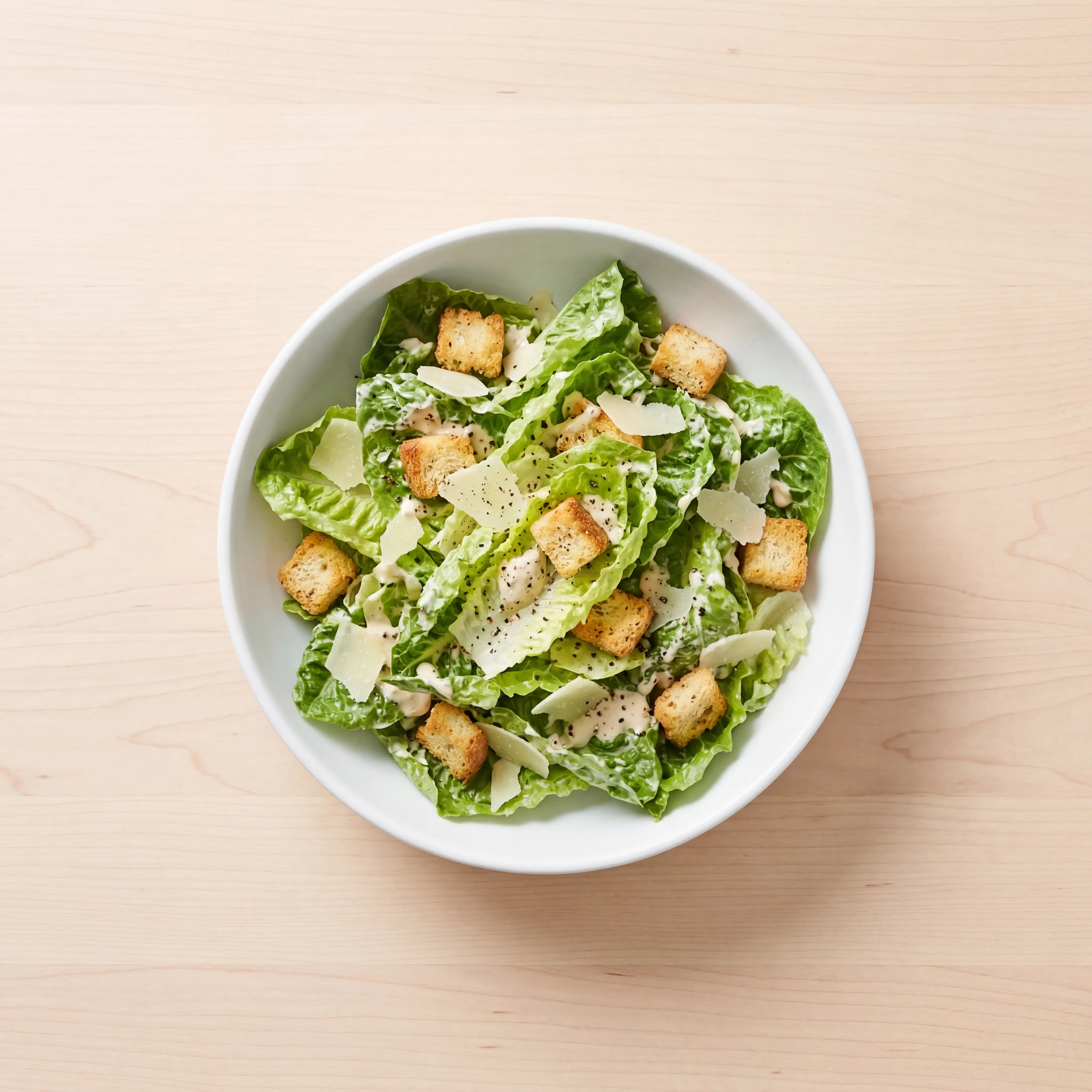 Caesar Salad von oben, helles Holz